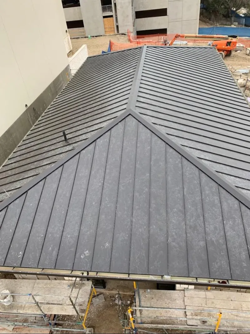 Commercial metal roof construction with crane equipment in Woodstock